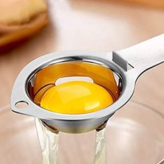 an egg is being squeezed into a glass cup