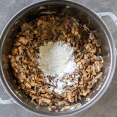 mushrooms are mixed together in a pot with some salt and pepper on the top side