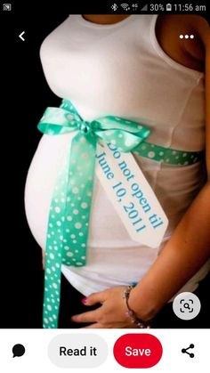 a pregnant woman wearing a white tank top and green polka dot ribbon around her waist