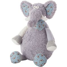 an elephant stuffed animal sitting on top of a white surface with blue and red flowers