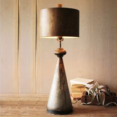 a lamp that is sitting on top of a table next to a book case and some books