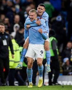 two soccer players are hugging each other on the field