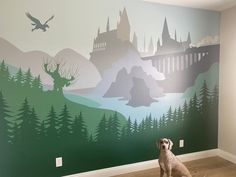 a dog sitting on the floor in front of a wall with hogwart's castle mural