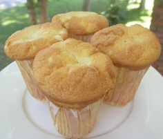 some muffins are sitting on a plate in the middle of a table outside