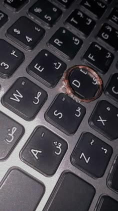 a ring sitting on the keys of a keyboard that is black and has white numbers