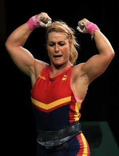 a female wrestler flexing her muscles on the stage with both hands behind her head