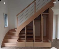 an empty room with wooden stairs and open closets on the side, in front of a window