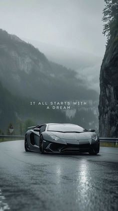 a black and white photo of a sports car on a road with mountains in the background