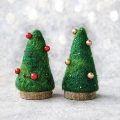 two small green christmas trees with red berries on them