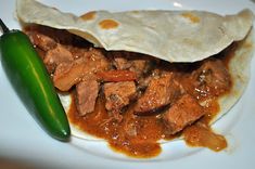 a white plate topped with meat and a green pepper