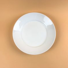 an empty white plate sitting on top of a table