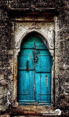 an old building with a blue door and arched window