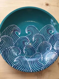 a blue bowl with waves painted on it