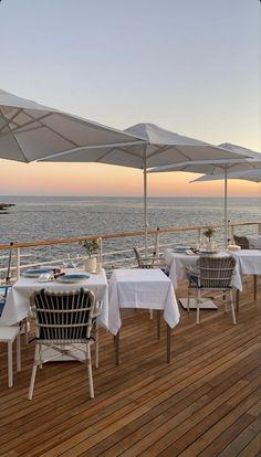 an outdoor dining area on the deck of a cruise ship with tables and chairs covered in white tablecloths