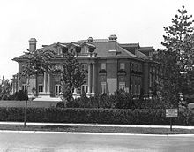 an old photo of a large house in the middle of trees and bushes around it