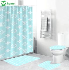 a bathroom with a blue shower curtain and two white rugs in front of the toilet