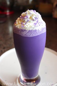 a purple drink with whipped cream and sprinkles