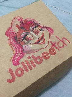 a cardboard box with a drawing of a woman's face on the side and words jollibee tech