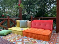 a colorful couch sitting on top of a wooden deck