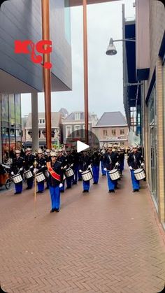 a group of people that are standing in the street with some drum'd drums