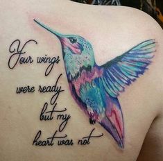 a colorful hummingbird tattoo on the back of a woman's upper arm and shoulder