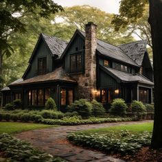 a large house in the woods with lots of trees and bushes around it's front entrance