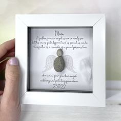 a person holding up a framed photo with an angel on it's back and the words above it