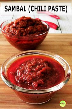 two bowls filled with chili paste on top of a wooden table