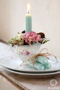 a white plate topped with a candle and flowers