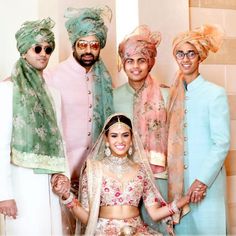 a group of people standing next to each other wearing turbans and scarves