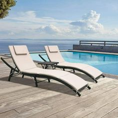 two lounge chairs next to an empty swimming pool