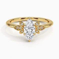 a yellow gold ring with a pear shaped diamond