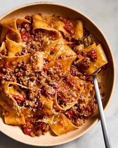 a bowl filled with pasta and meat sauce