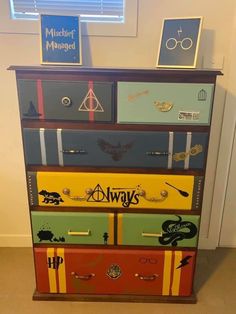 a multicolored dresser with harry potter stickers on the top and bottom drawers