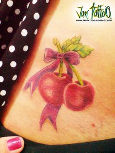 a woman's stomach with a bow and cherries tattoo on it