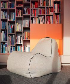 a bean bag chair sitting in front of a bookshelf