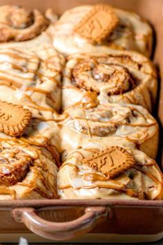 a pan filled with cinnamon rolls covered in icing