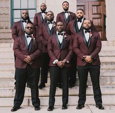 a group of men standing next to each other in front of a door wearing suits and bow ties