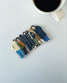 a group of figurines sitting next to a cup of coffee