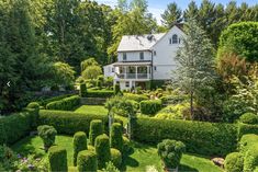 a large white house surrounded by trees and bushes