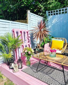 a pink bench sitting in the middle of a yard with potted plants on it