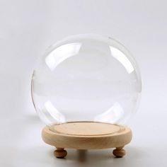 a clear glass ball sitting on top of a wooden stand