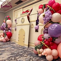 balloons and garlands are on display at the entrance to a balloon - filled ballroom