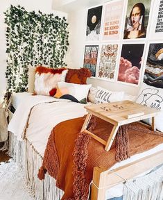 a bed room with a neatly made bed and lots of pictures on the wall behind it