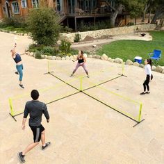 four people are playing tennis in the yard