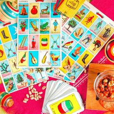 some cards are laying out on a pink table cloth with other items to make it look like they have been used for many years