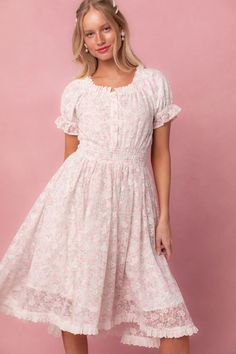 Expertly crafted, the Esmee Dress in Floral offers a delicate white base with a stunning floral lace overlay. The round neckline framed with eyelet trim adds a touch of elegance, while the elastic waistband offers a comfortable and flattering fit. Functional buttons and a knee-length skirt make it both stylish and prac Feminine Floral Dress With Smocked Back For Daywear, White Floral Dress With Lace Trim For Garden Party, Spring Floral Dress With Lace Trim For Daywear, White Feminine Floral Dress With Smocked Bodice, White Floral Dress With Smocked Bodice, Modest Sundress, Starry Night Dress, Modest Dresses For Women, Ivy City Co