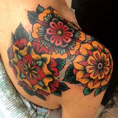 a close up of a woman's shoulder with colorful flowers on her left side