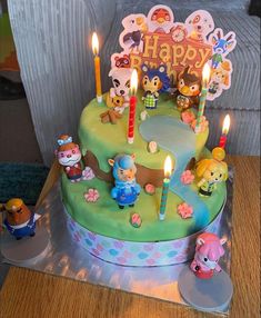 a birthday cake decorated with cartoon characters and candles