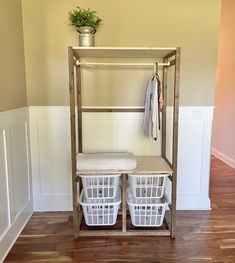 a shelf with baskets and clothes hanging on it